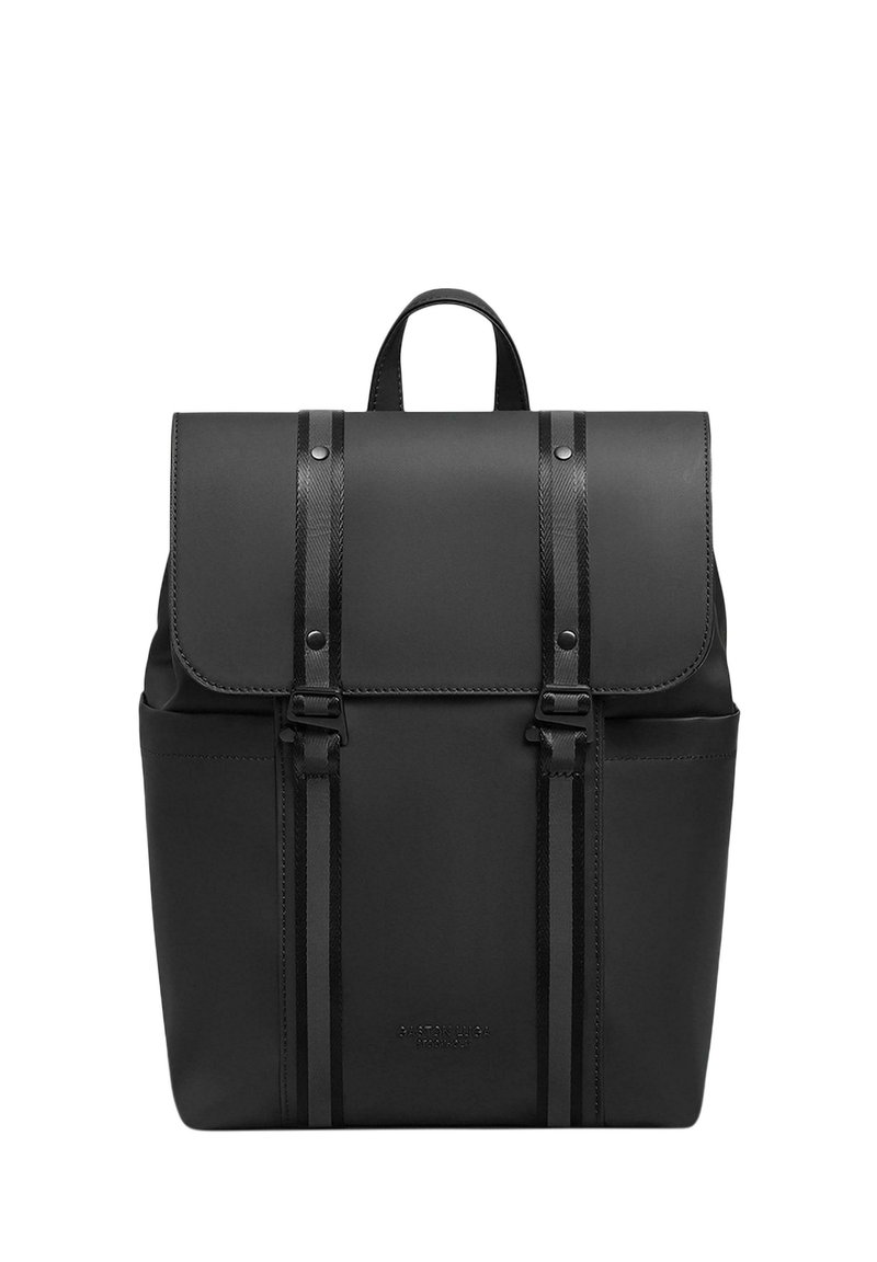 Mochila negra hecha de material liso, con una solapa plegable y correas de hebilla, un asa en la parte superior y bolsillos laterales. Diseño limpio sin patrones.