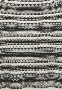 Tissu tricoté noir et blanc avec des rayures horizontales alternées présentant des motifs variés en points et en traits.
