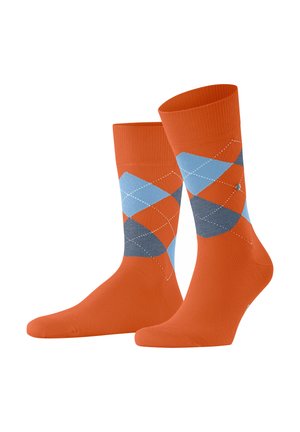 Une paire de chaussettes de sport orange avec un motif argyle bleu et gris et des accents en diamant blancs cousus.
