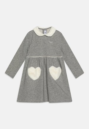 Vestido gris de manga larga con un suave cuello blanco esponjoso y acentos de bolsillos en forma de corazón, hecho de una tela suave con una cintura fruncida.