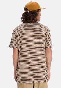 Camiseta de mangas cortas a rayas en beige, marrón y crema. Tejido suave con un corte relajado, con cuello redondo y dobladillo recto.