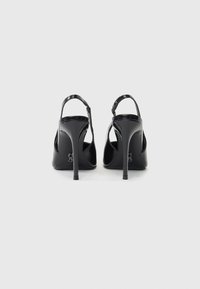 Μαύρα ψηλοτάκουνα παπούτσια με γυαλιστερό πατίνι, που διαθέτουν λεπτό τακούνι στιλέτο και ανοιχτή πίσω σχεδίαση με λεπτό λουράκι στον αστράγαλο.