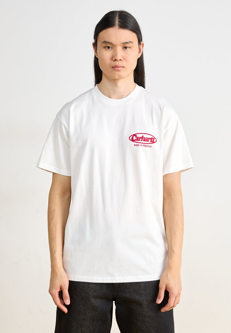 Camiseta de algodón blanca con un logo rojo en el lado izquierdo del pecho que dice "Carhartt WORK IN PROGRESS". Diseño de mangas cortas y cuello redondo.