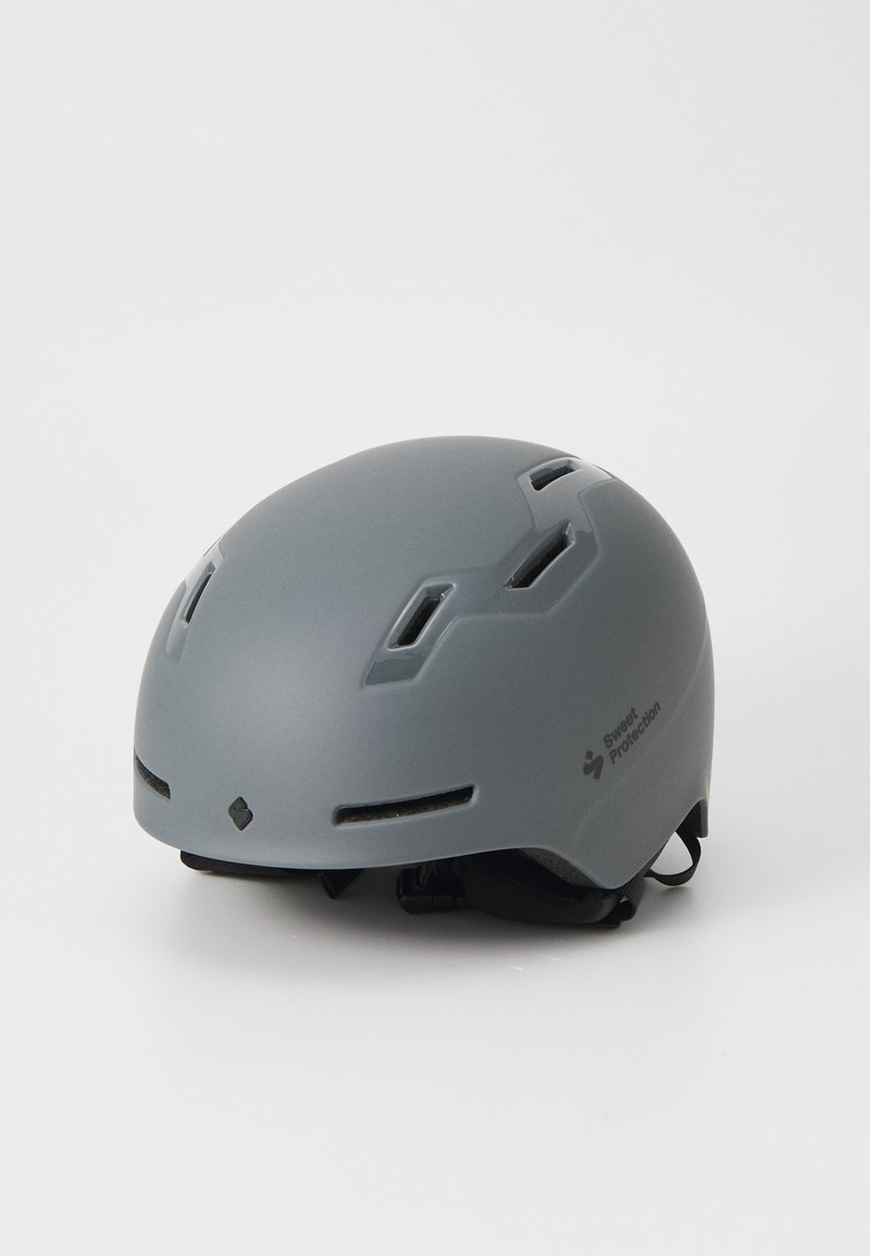 Gray helmet with ventilation slots, lightweight design, matte finish, and adjustable straps. Brand logo visible on the side.