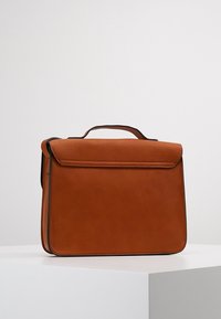 Hnědá kožená taška obdélníkového tvaru, hladkého povrchu, s horním uchem a jednoduchým klopovým uzávěrem. Minimalistický design, bez viditelného kovového prvku.