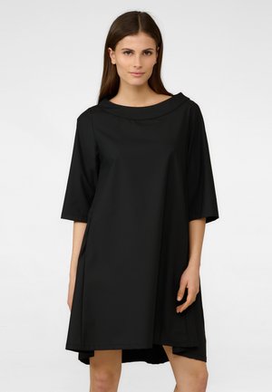 Abito corto nero a maniche corte con una vestibilità comoda, scollatura tonda e orlo asimmetrico. Realizzato in tessuto morbido con dettagli minimi.