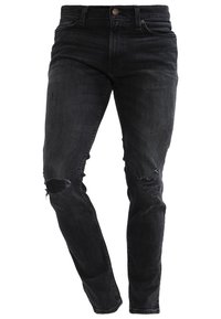Vaqueros de denim negro con un ajuste slim, áreas desgastadas en las rodillas y un ligero desteñido. Fabricados con un material suave y flexible para mayor comodidad.
