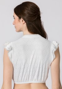 White embroidered crop top with puff sleeves, featuring floral patterns and eyelet details, gathered hem, and a soft, textured fabric.
