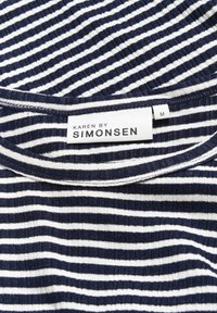 Tessuto a righe blu navy e bianche, texture morbida, scollatura rotonda, etichetta con il marchio "KAREN BY SIMONSEN," taglia "M" visibile.
