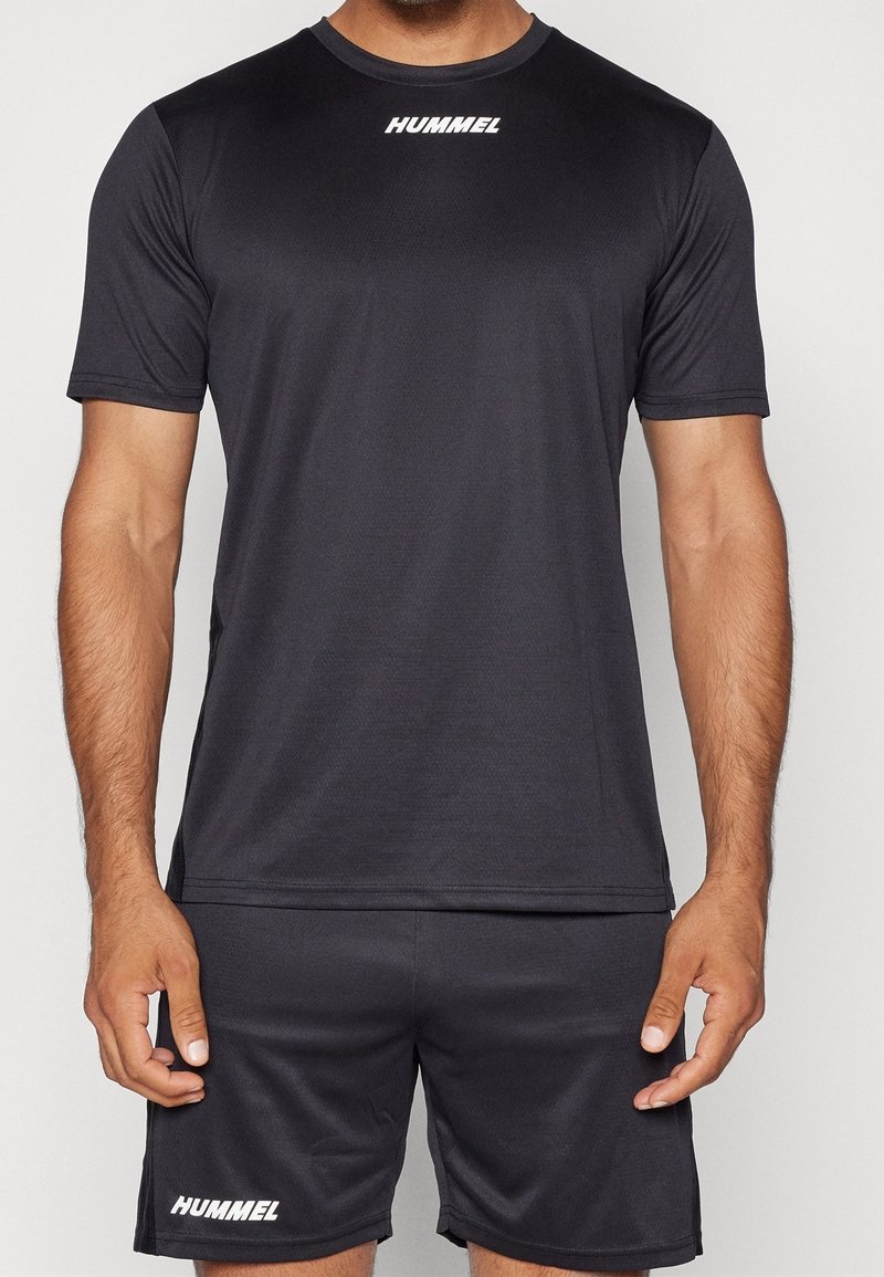 Czarny sportowy T-shirt z krótkim rękawem, gładka faktura, z białym logo "HUMMEL" na piersi, w komplecie z dopasowanymi szortami.
