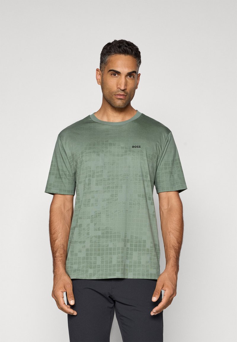 T-shirt vert à manches courtes avec un motif à carreaux texturé, col rond, et logo 'BOSS' en noir sur la poitrine.