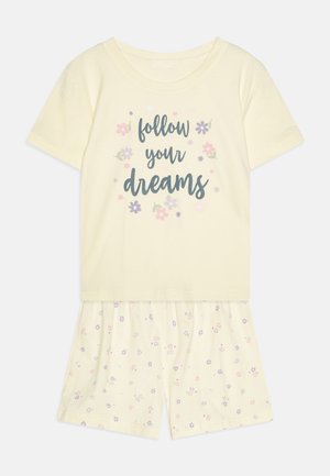 Gelbes Baumwoll-Pyjama-Set mit einem Kurzarmoberteil, das den Text "folge deinen Träumen" und florale Muster auf den passenden Shorts aufweist.