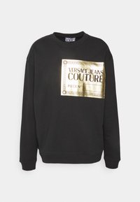 Svart sweatshirt med ett guld rektangulärt logotryck med texten "VERSACE JEANS COUTURE". Långa ärmar och ribbade muddar.
