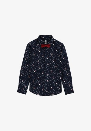 Camisa de manga larga azul marino con botones, con estampado blanco de copos de nieve y pájaros, combinada con una pajarita roja en el cuello.