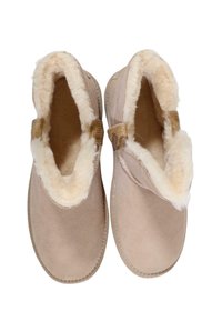 Zapatillas de invierno color beige sin cordones, con suave forro de piel crema y una pestaña decorativa en la parte superior, diseñadas para ofrecer comodidad y calidez en el interior.