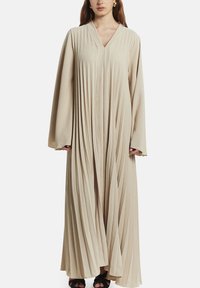 Beige geplooide lange jurk met een V-hals en lange mouwen. Gemaakt van lichtgewicht stof, met een verticale textuur over het geheel.