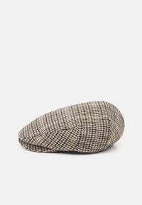 Flat cap in a houndstooth pattern, featuring shades of brown, cream, and black. Made from textured fabric with a rounded shape.