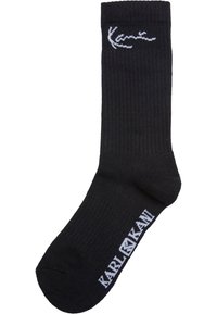Schwarze gerippte Socken aus Baumwollmischung, mit einem weißen Logo an der Seite und verstärktem Zehenbereich. Mittellange Sockenlänge mit glatter Textur.