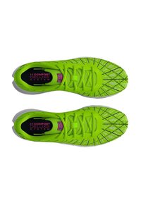 Un par de zapatillas deportivas de color verde brillante con un patrón de diamantes negros, cordones y el texto "Sistema de Comodidad Deluxe" en el área del talón.