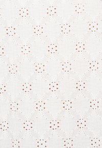 Witte stof met een ingewikkeld diamanten patroon met uitsparingen en kleine vierkante accenten doorheen. Zachte textuur, lichtgewicht ontwerp.