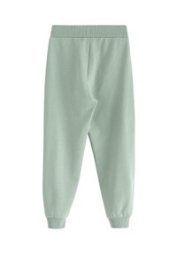 Ljusgröna sweats i mjukt tyg, med elastisk midja och avslutade anklar. Slät textur utan synliga mönster.