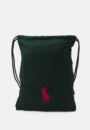 Borsa a drawstring verde realizzata in un morbido tessuto, con un logo ricamato rosa ben visibile di un giocatore di polo in azione.