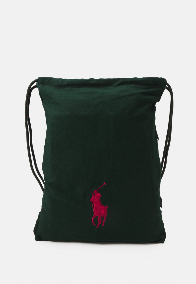 Green drawstring bag made of soft fabric, featuring a prominent pink embroidered logo of a polo player in action.