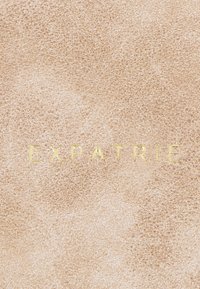Surface texturée beige clair avec le mot « EXPATRIÉ » embossé en doré, centré horizontalement et verticalement.