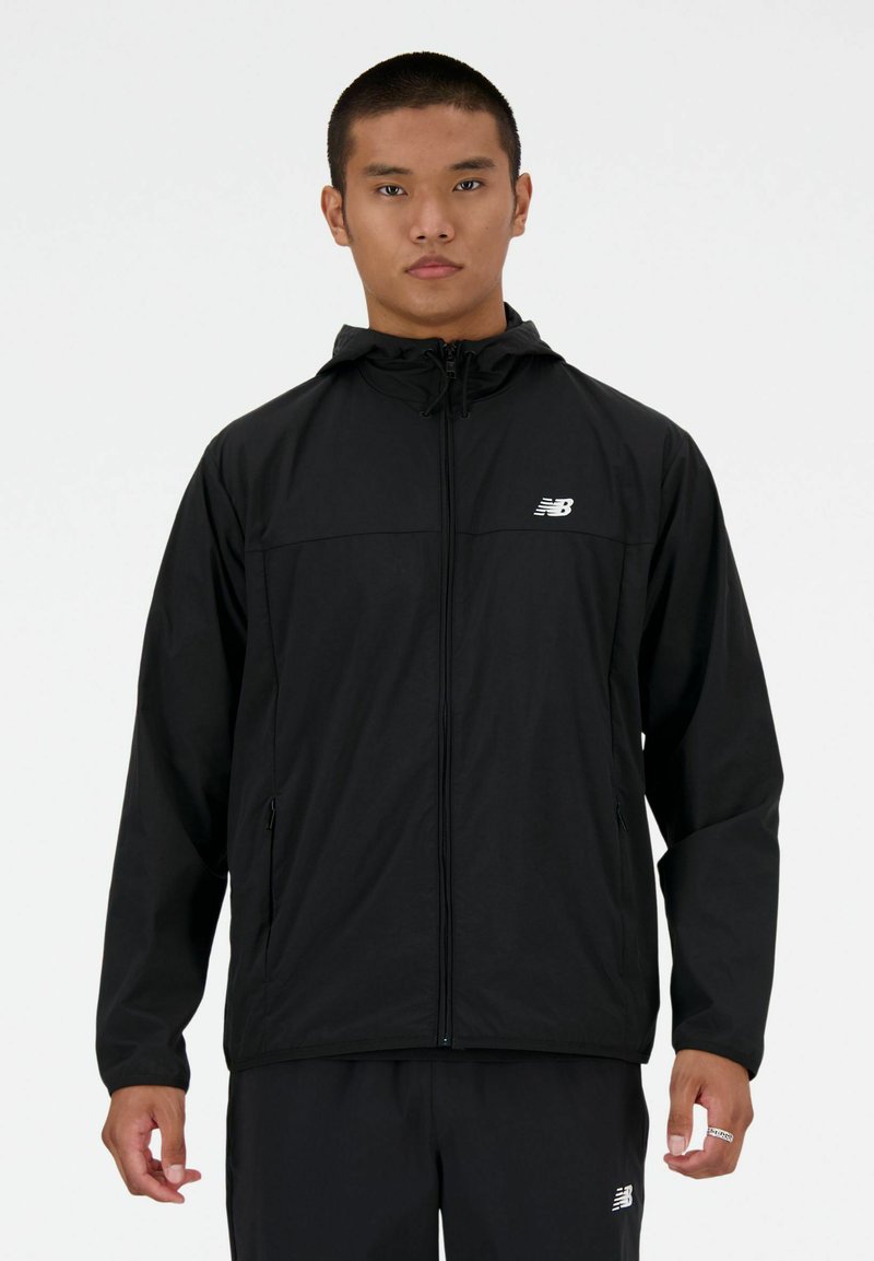 Sort zip-up jakke med hætte, lavet af letvægtsmateriale. Har en brystlomme, sidelommer og et hvidt logo på venstre bryst.