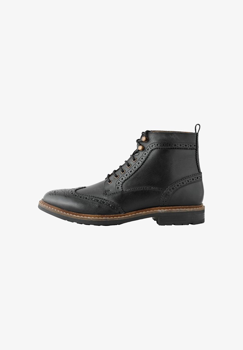 Must häbemust nahast meeste brogue sallikingadega, dekoratiivsete perforatsioonidega, pruuni äärega ja kummitald.