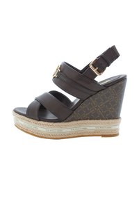 Brown leather wedge sandal with adjustable ankle strap, woven jute detail, and branded platform. Features two wide straps across the front.