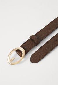 Brown textured leather belt with a gold circular buckle. Features a smooth finish, pointed tip, and a single loop for adjustment.
