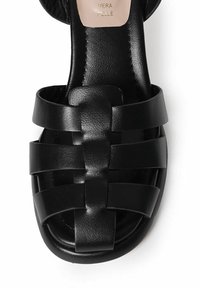 Sandal nera in pelle con strisce intrecciate, design open toe, texture liscia e forma minimalista. All'interno è impresso il nome del marchio.