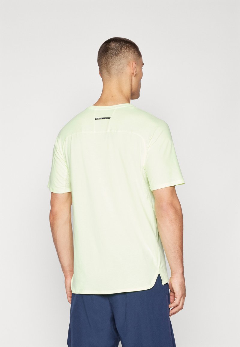 T-shirt léger vert clair à manches courtes, en tissu léger, avec un col rond et une petite étiquette noire dans le haut du dos. Fentes latérales au niveau de l'ourlet.