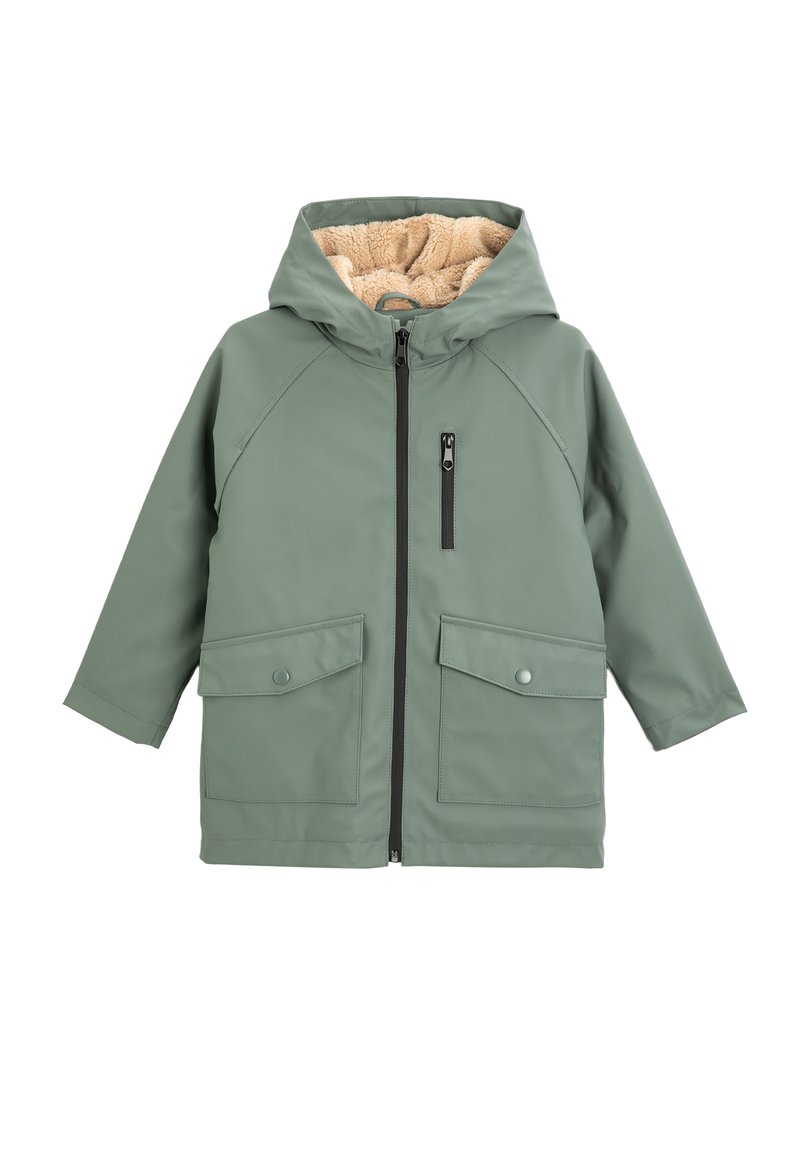 Grön vattentät jacka med huva, fodrad med beige fleece. Har en framsidans dragkedja, en bröstficka och två stora framfickor.