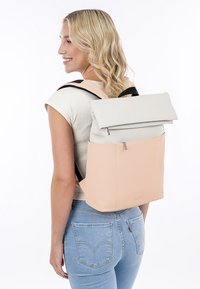Rucksack mit Rollenverschluss in Hellgrau und Pfirsich mit schwarzen Riemen. Glatte Textur, minimalistisches Design und vorderes Reißverschlussfach.