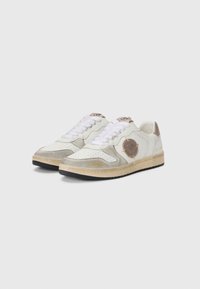 Sneaker bianche da atletica con dettagli in camoscio grigio chiaro, logo dorato, punta perforata e lacci bianchi piatti. Suola in gomma nera.