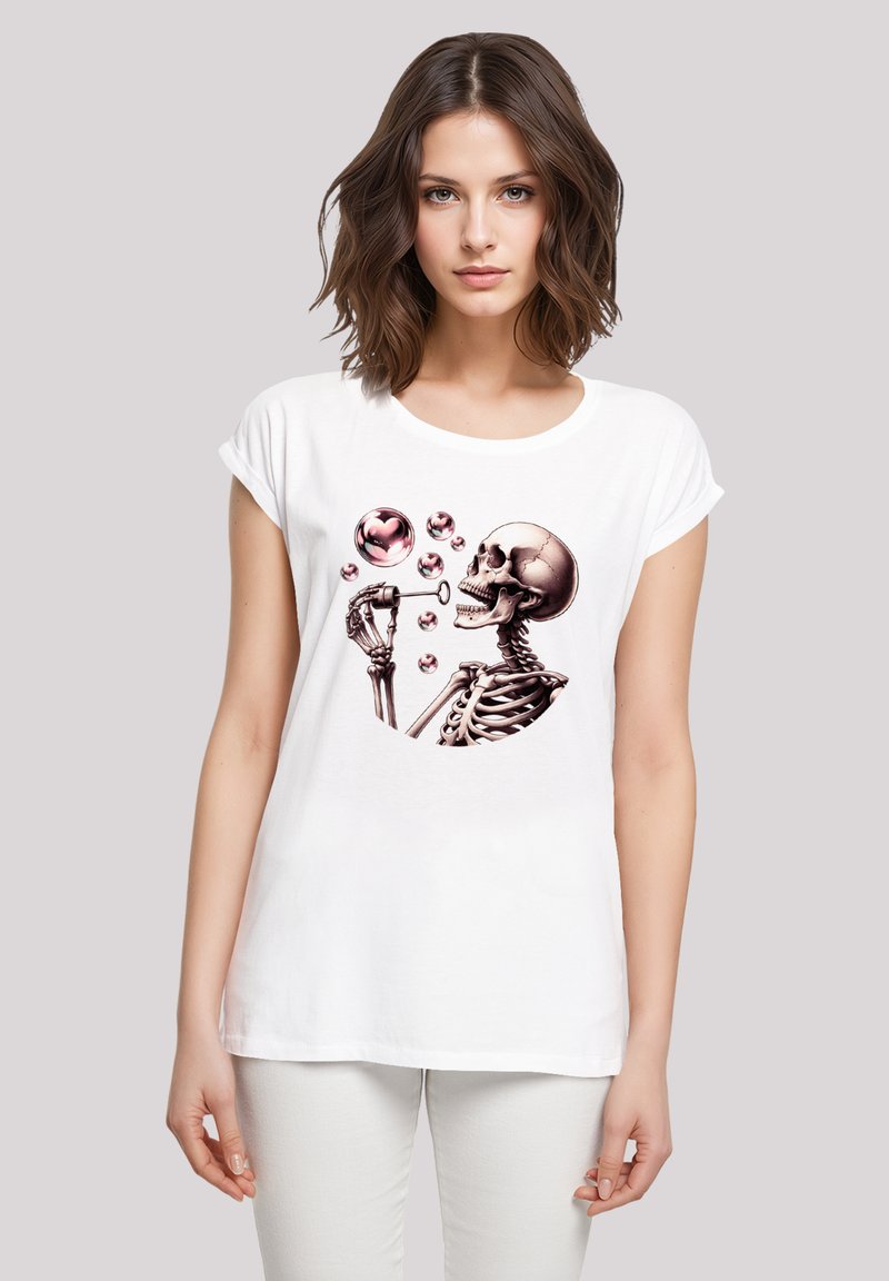 Weißes Baumwoll-T-Shirt mit einem grafischen Design eines Skeletts, das rosa Blasen, einschließlich einer herzförmigen Blase, blasst. Entspannte Passform, umgeschlagene Ärmel.