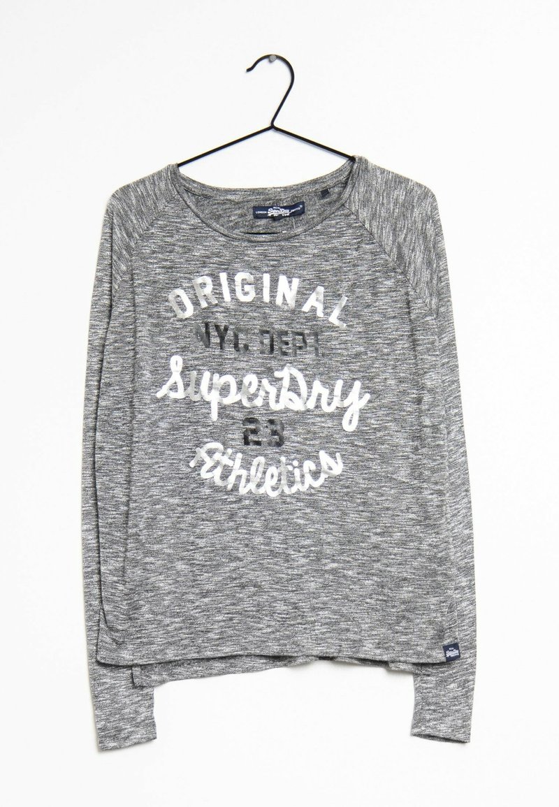 Pull gris chiné à col rond et manches longues avec le texte « Original SuperDry Athletics », suspendu sur un cintre noir contre un fond blanc.