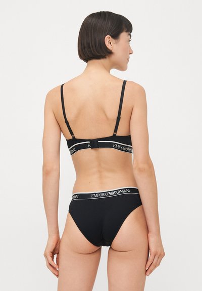 Zwart lingerieset met een bralette met verstelbare bandjes en een haaksluiting, gecombineerd met bijpassende bikini-slipjes met een logo-elastiek.