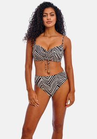 Zwart-witte bikini met zebra-strepen, voorzien van een gerimpeld top met verstelbare bandjes en een hooggetailleerde broek. Zachte, gestructureerde stof.