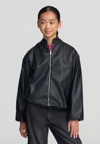 Giacca bomber nera in pelle ecologica con colletto alto, zip frontale e tasche laterali. Vestibilità comoda con volume nelle maniche. Finitura texturizzata.