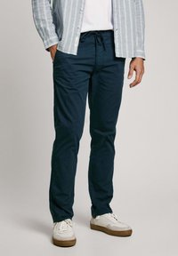 Mornarsko modri hlače s sproščenim krojem, izdelane iz lahkega materiala. Imajo elastičen pas s vrvico in stranske žepke.