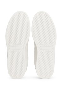 Semelles de baskets blanches avec un motif texturé en losanges. Comprend une étiquette de logo portant l'inscription "TOMMY JEANS." Design de bords lisses, bouts arrondis.