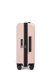 Harde koffer in lichtroze met verticale ribbels, zwarte rits, ingebouwd slot met combinatie, uitschuifbare handgreep en vier wielen.