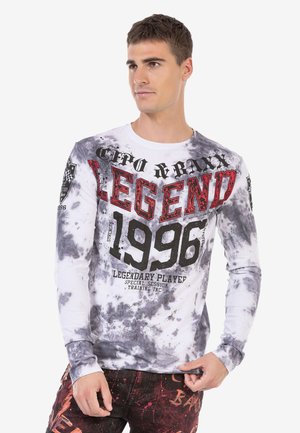 Long-sleeve, tie-dye shirt in white and gray with red and black graphic text, featuring the year "1996" and logo details on sleeves.