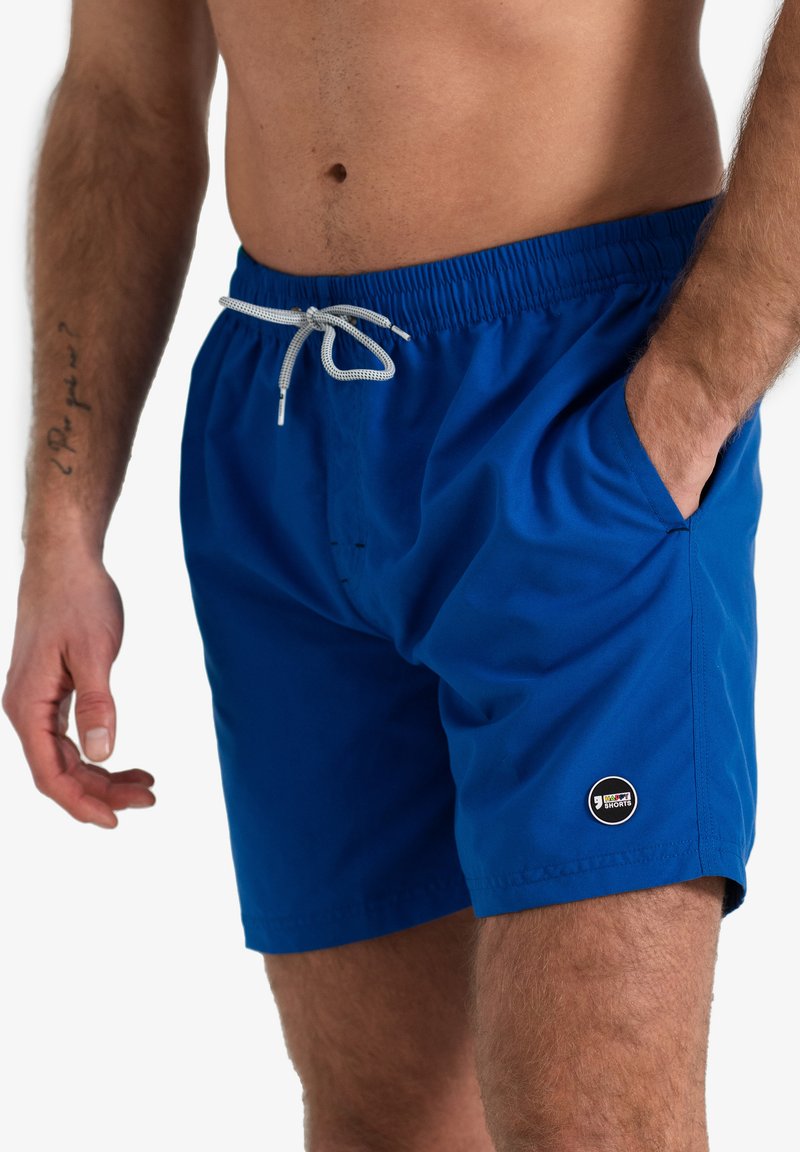 Blauwe zwembroek van lichtgewicht stof met een elastische tailleband, trekkoord, zijzakken en een klein logo op de zoom.