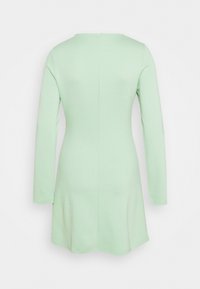 Långärmad klänning i mjukt, ljusgrönt tyg, med rund halsringning och en figurnära liv som svänger lätt vid fållen.