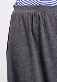 Grauer Rock mit elastischem Bund, aus weichem Stoff, mit gerafften Details am Bund und einer glatten Textur.