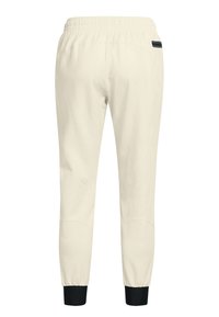 Cream-colored jogger pants with an elastic waistband, tapered legs, and black cuffs. Smooth fabric with minimal seams and a side pocket accent.